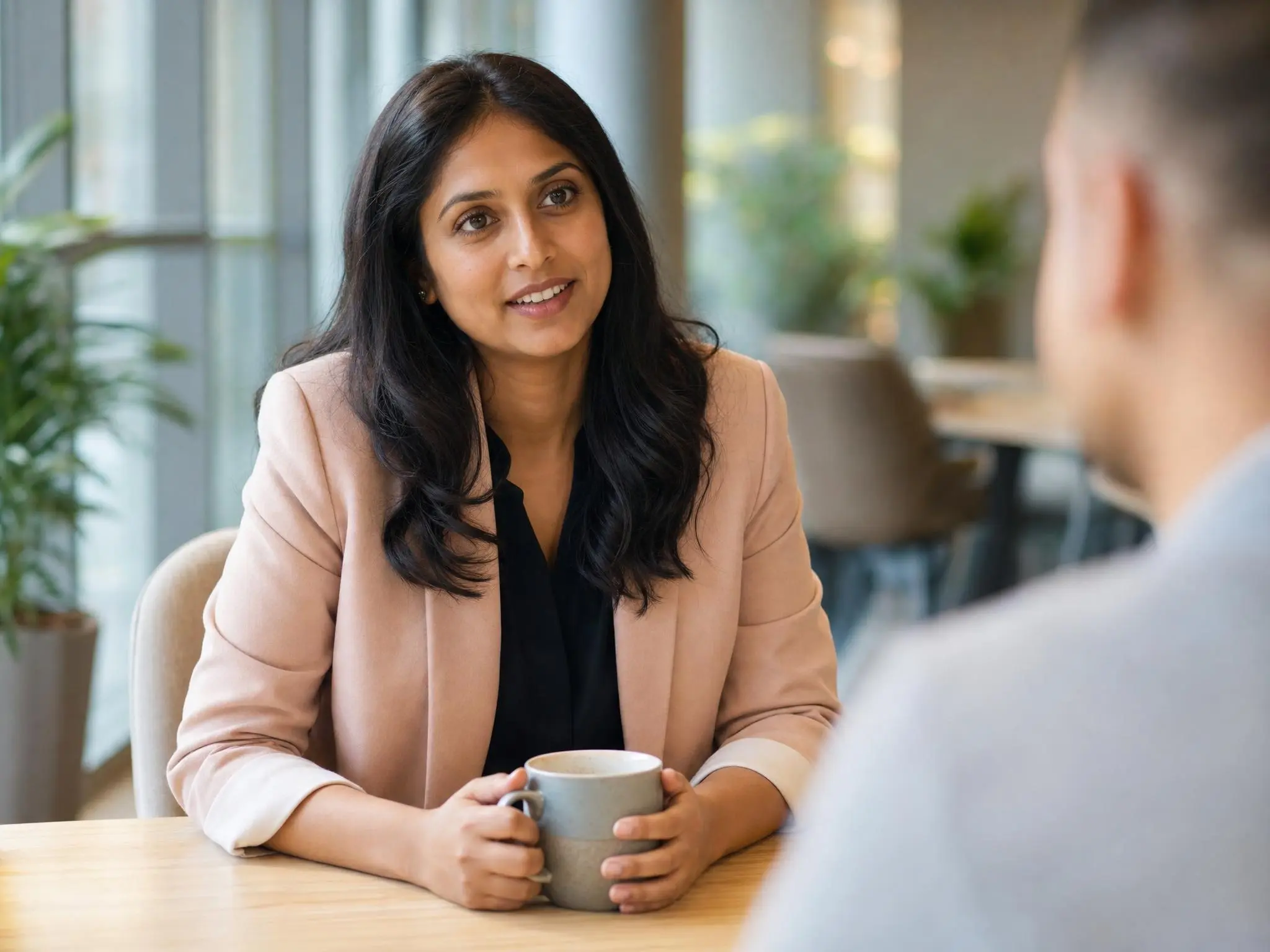 A WRSS account manager mid-conversation with a client over coffee.